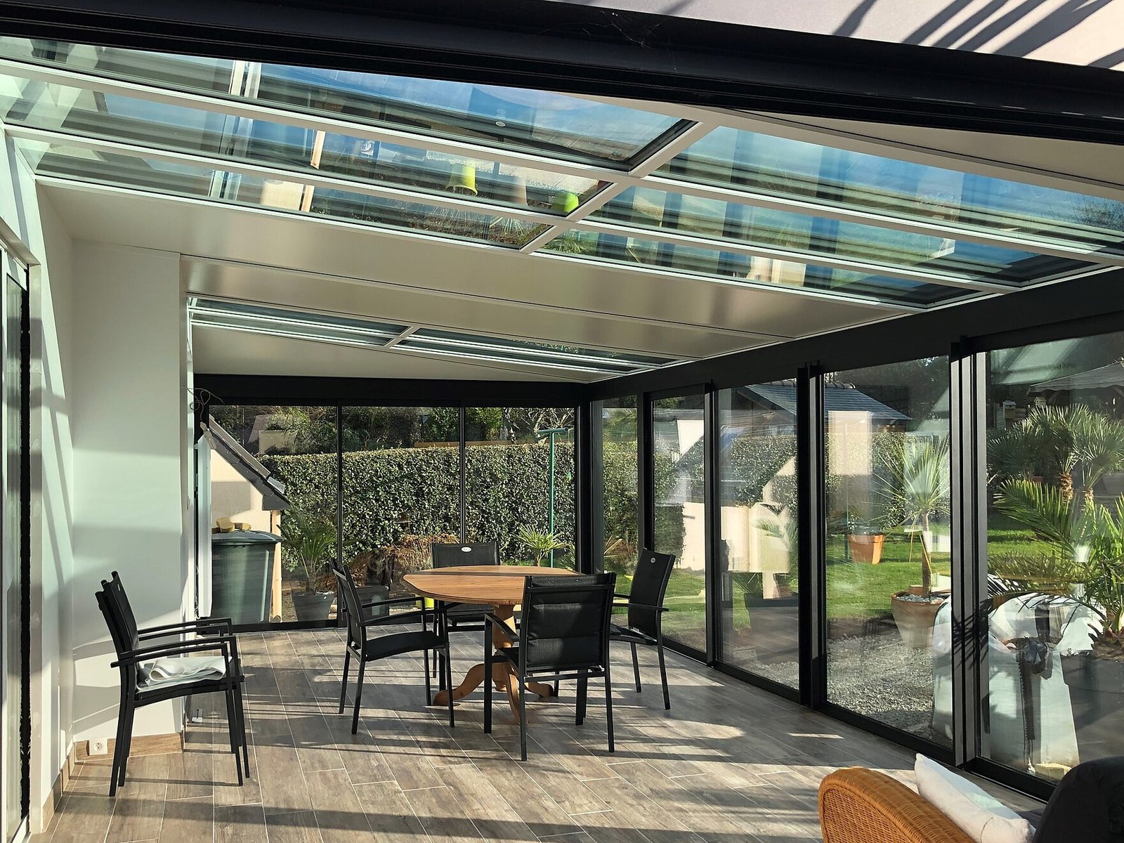 Glas-Veranda von innen mit Glasdach, Glasschiebewänden und Essplatz